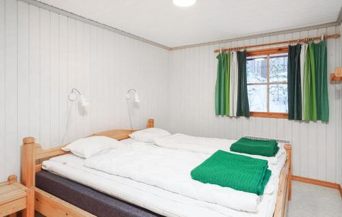 洛夫斯达伦Awesome Home In Lofsdalen With Kitchen的卧室配有带绿色床单的大型白色床