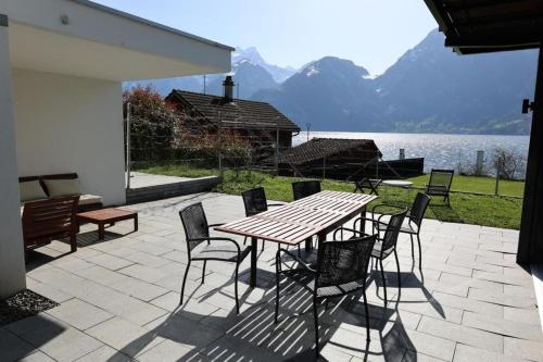 希希崆Ferienvilla am See 3 für 2-4 Personen的湖畔庭院里的木桌和椅子