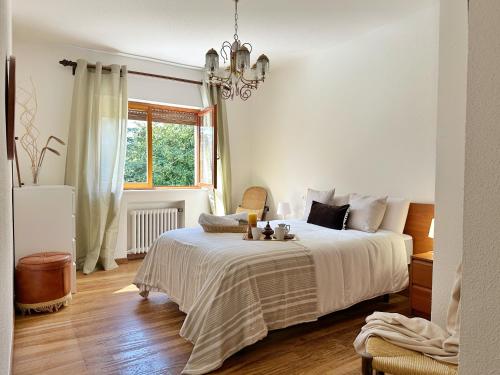 诺哈Villa La Hojarasca - 6820的白色卧室配有一张床和一个吊灯