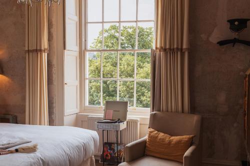 巴斯No 15 by GuestHouse, Bath的一间卧室设有一张床、一个窗口和一把椅子