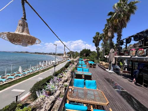 锡德Cuba Beach Hotel的海边木板路上的一排蓝色椅子