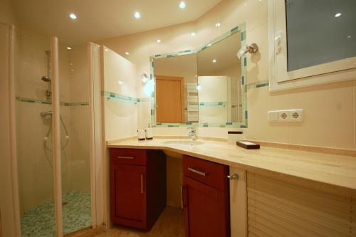 滨海托萨LETS HOLIDAYS SEA VIEWS APARTMENT & POOL in SA GABARRA的一间带水槽、淋浴和镜子的浴室