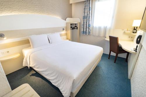 阿普瓦尼基里亚德奥克斯尔阿伯尼酒店的酒店客房设有一张白色大床和一张书桌