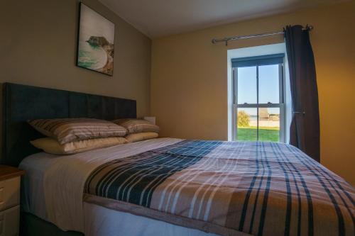 BallylongfordCarrig Island Lodge的一间卧室设有一张床和一个窗口