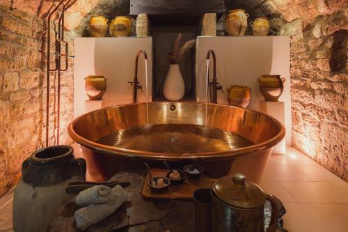 巴斯No 15 by GuestHouse, Bath的一个大铜浴缸,位于一个有花瓶的房间