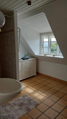 凯隆堡Room in Ubby (Near Kalundborg)的阁楼浴室设有浴缸和窗户。