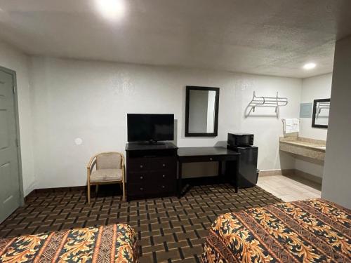 艾达Budget Inn Ada的酒店客房配有书桌和床。
