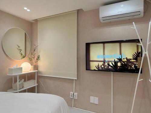 釜山Hoho House的卧室配有一张床,墙上配有电视。