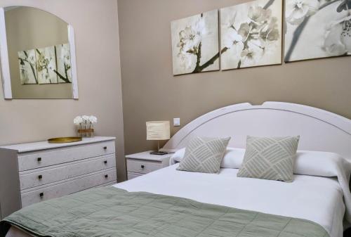 诺哈Vivienda Verano的卧室配有白色的床和梳妆台。