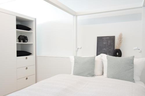 诺伊豪森Löwe Apartment Grau Rooftop am Rheinfall的白色卧室配有白色的床和梳妆台