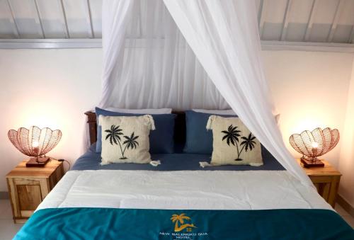 吉利阿尔New Balengkudua Hotel的一间卧室配有一张棕榈树的天蓬床。