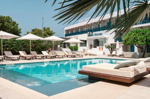 爱琴娜岛达娜厄酒店的一个带躺椅的游泳池和一间酒店