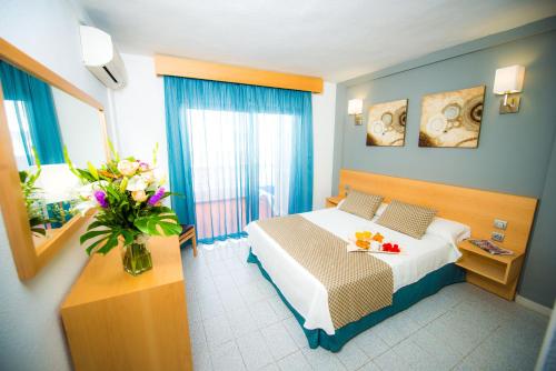 圣地亚哥港奥纳埃尔马尔克斯酒店的配有一张床和花瓶的酒店客房