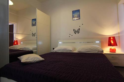洛帕德Apartments Cervelin的一间卧室设有两张床,墙上挂着蝴蝶。