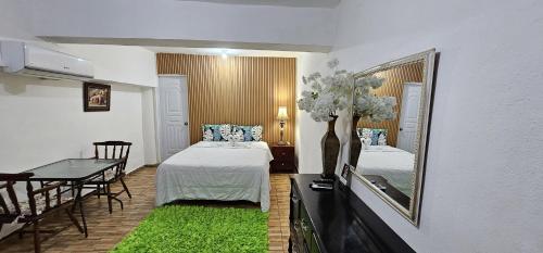 圣多明各Hotel Cana Palma Zona Colonial的客房设有床、镜子和桌子