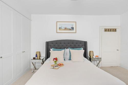 达特茅斯10 Clarence Hill - Elegant Town House with outside space的卧室配有带蓝色枕头的大型白色床