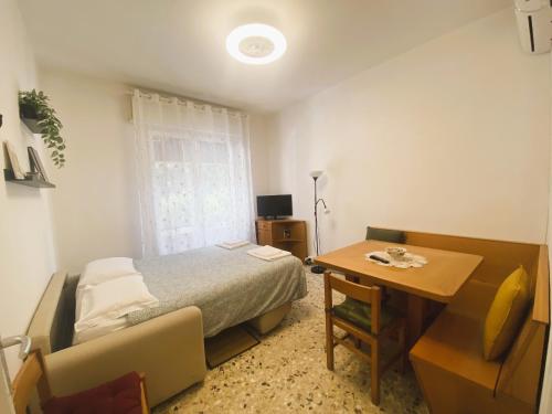 比萨Ad Agio Apartments的一间卧室配有一张床、一张桌子和一张桌子