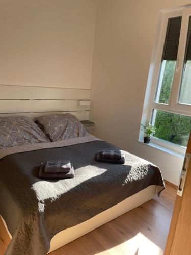 塞格德Hexagon Apartman Szeged的一间卧室配有一张床,上面有两条毛巾
