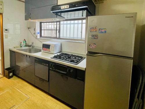 东京池袋至近完全貸切一軒家的厨房配有不锈钢冰箱和水槽