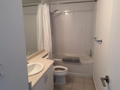 多伦多Downtown Condo的白色的浴室设有卫生间和水槽。