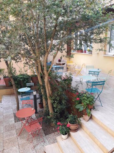 锡耶纳密涅瓦酒店的庭院配有桌椅和一棵树