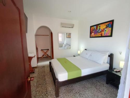 吉拉尔多特里卡德别墅酒店的卧室配有一张带绿毯的白色床