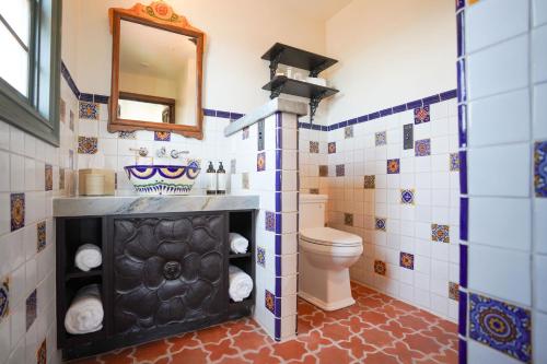 Capistrano BeachEl Caminante Bar & Bungalows的一间带卫生间和镜子的浴室