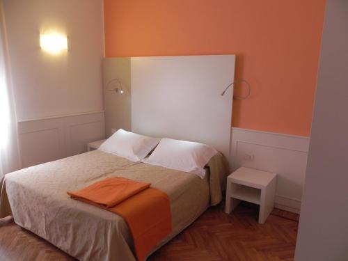 斯特雷萨马泽尼大街住宅酒店的一间小卧室,配有一张带橙色墙壁的床