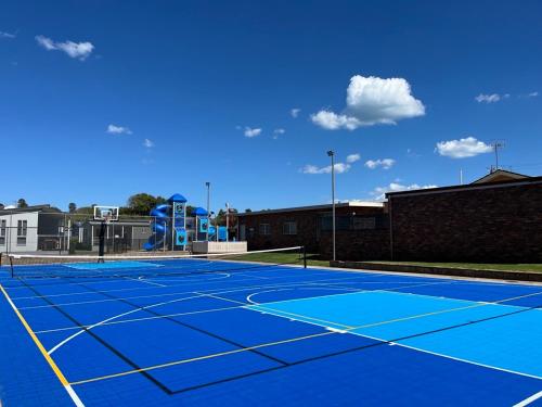 沃纳姆堡BIG4 Tasman Holiday Parks - Warrnambool的蓝色的网球场,上面设有游乐场