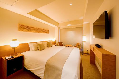 京都THE GENERAL KYOTO Bukkouji Shinmachi的一间酒店客房,配有一张大床和一台平面电视