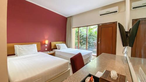 梭罗Lorin Dwangsa Solo Hotel的酒店客房设有两张床和窗户。