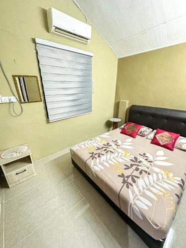 峇六拜Dusun Indah Cottage 3的一间卧室配有一张床,窗户配有百叶窗