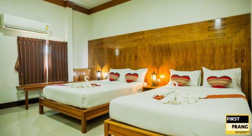 通萨拉First and Frang Hotel - Koh Phangan的一间卧室配有两张带白色床单和红色枕头的床。