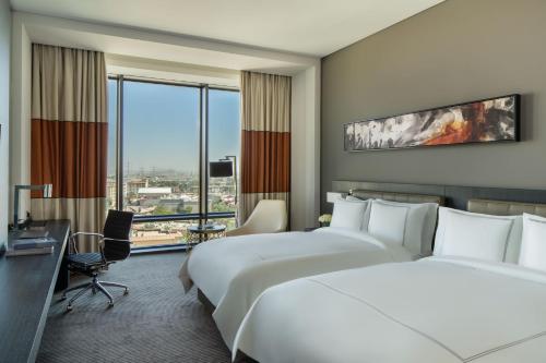 利雅德Fairmont Riyadh的酒店客房配有两张床和一张书桌
