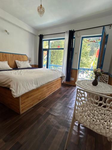 马拉里Tiny Spot Hostel的卧室配有床、桌子和窗户。