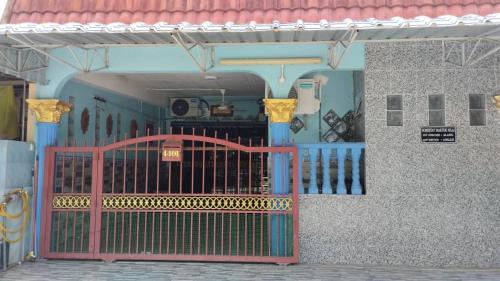 汝来Maktok's Nilai Homestay的红色大门的建筑物入口
