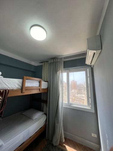 亚历山大Downtown Sea View Suites的一间卧室设有两张双层床和一扇窗户。