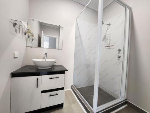 朱里恩湾Unit 51 Seafront Estate的带淋浴和盥洗盆的白色浴室