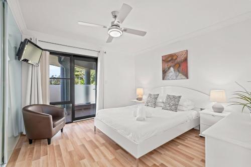 特里格尔Spacious Modern Apartment with Breathtaking Views的白色卧室配有床和椅子