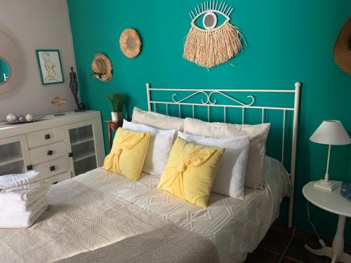 AsqueApartamentos la Jayma del Arte的蓝色卧室配有带黄色枕头的床