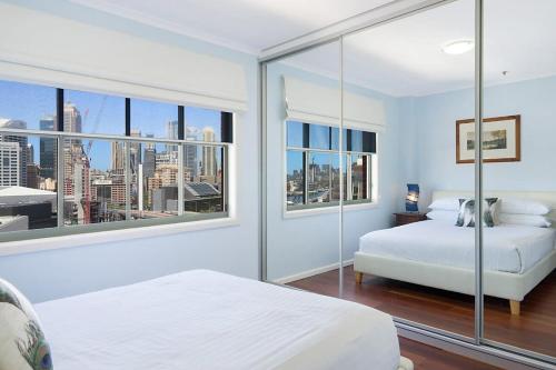 悉尼Perfect Pyrmont penthouse with Sydney Tower View的一间卧室设有两张床和大窗户