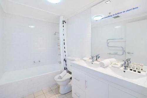 悉尼Perfect Pyrmont penthouse with Sydney Tower View的白色的浴室设有浴缸、卫生间和水槽。