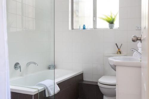 悉尼Sunny Apartment in Quiet and Green Neighbourhood的带浴缸、卫生间和盥洗盆的浴室