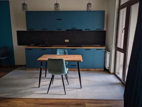 卡兹贝吉Milky Way的厨房配有蓝色橱柜、木桌和椅子