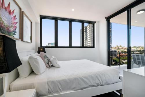 布里斯班Convenient 2-Bed Apartment with Panoramic Views的卧室设有白色的床和大窗户