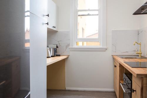 悉尼Central 2-Bed Apartment with Private Parking的厨房设有白色的墙壁和窗户。