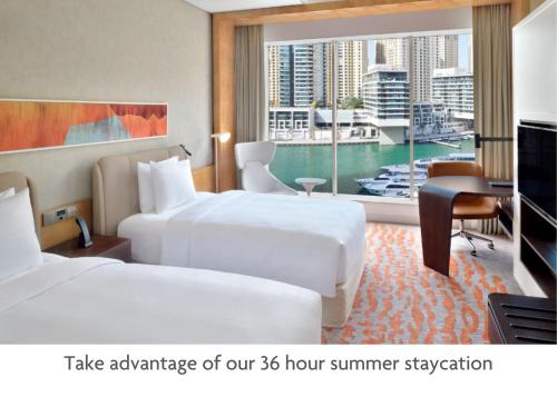 迪拜Crowne Plaza Dubai Marina, an IHG Hotel的酒店客房设有两张床和电视。