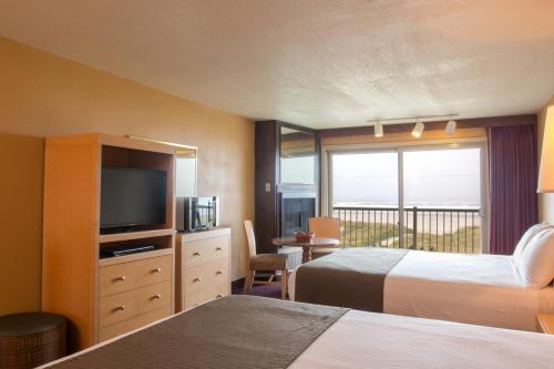 西塞德喜潮海滨酒店 的酒店客房设有两张床和电视。