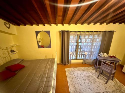 蓬塔谢韦Agriturismo Tassinaia的一间卧室配有一张床、一张桌子和一个窗户。