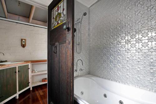 卢拉Little Haven Leura Cottage with Spa Bath and BBQ的带浴缸和淋浴的浴室